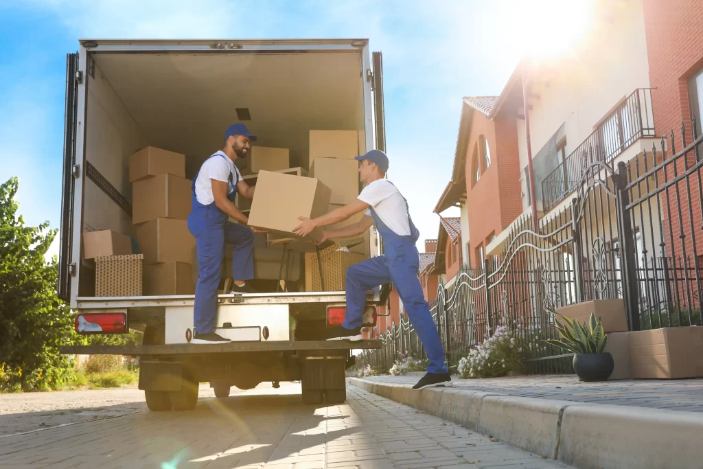Professional cross-country movers loading furniture into a moving truck.